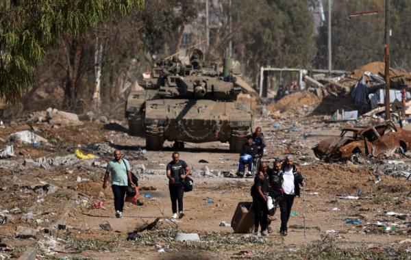 فلسطينيون نازحون عبر طريق صلاح الدين في حي الزيتون بمدينة غزة يوم 24 نوفمبر الماضي (أ ف ب)