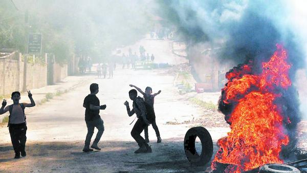 فلسطينيون يحرقون إطارات خلال مواجهات مع القوات الإسرائيلية في جنين (ا ف ب)