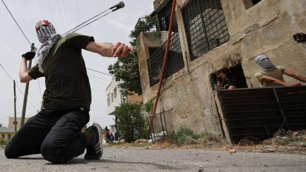 فلسطيني يرشق القوات الإسرائيلية بالحجارة في بلدة كفر قدوم (ا ف ب)