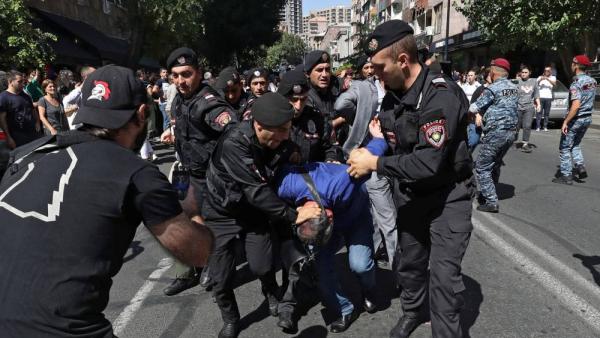 ضباط الشرطة يعتقلون متظاهرين خلال مسيرة مناهضة للحكومة في يريفان. (رويترز)