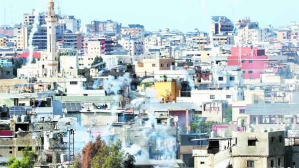 الدخان يتصاعد فوق المباني في مخيم عين الحلوة للاجئين الفلسطينيين بعد انهيار وقف إطلاق النار (اف ب)