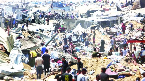 فلسطينيون يتفقدون الدمار في مخيم للنازحين بعد توغل دبابات إسرائيلية في خان يونس 