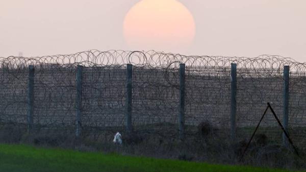 صورة لغروب الشمس فوق السياج الحدودي بين إسرائيل وغزة (رويترز)