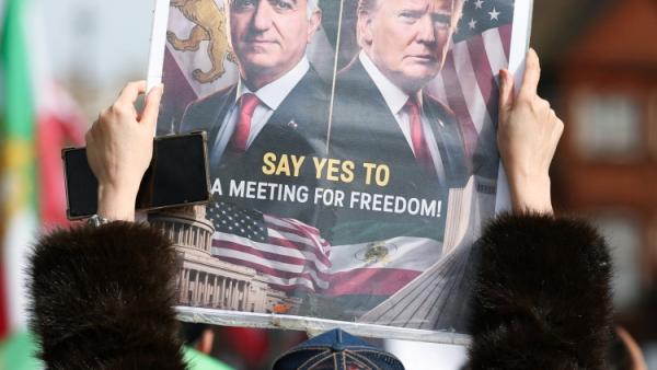 تحمل لافتة عليها صورة رضا بهلوي وترامب خلال احتجاج في لندن (4 أبريل 2026 / رويترز)