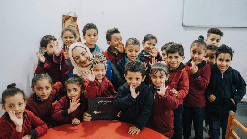 مروة العقروبي مع بعض الأطفال المستفيدين من الكتب