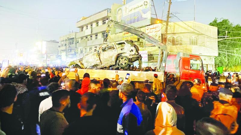 عراقيون يتجمعون في موقع مركبة استهدفتها غارة أمريكية ببغداد (اب