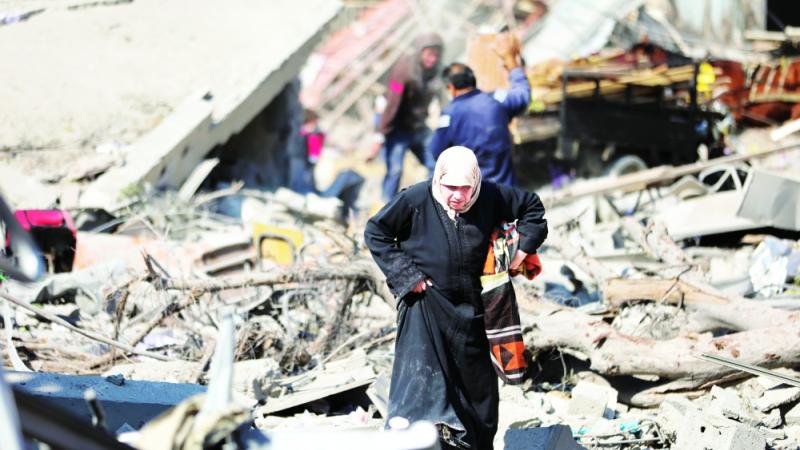 فلسطينية تسير وسط الدمار الذي خلفه القصف الإسرائيلي في مدينة غزة (أ ب)