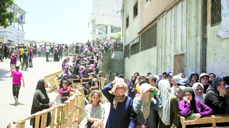 فلسطينيون يصطفون للحصول على أكياس الدقيق التي يوزعها برنامج الغذاء العالمي في مدينة غزة 