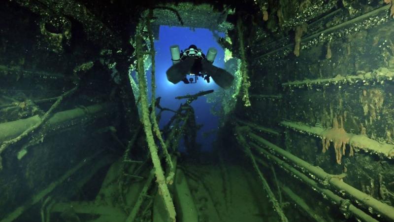 غواص يتجول بين حطام السفينة (أ.ف.ب)