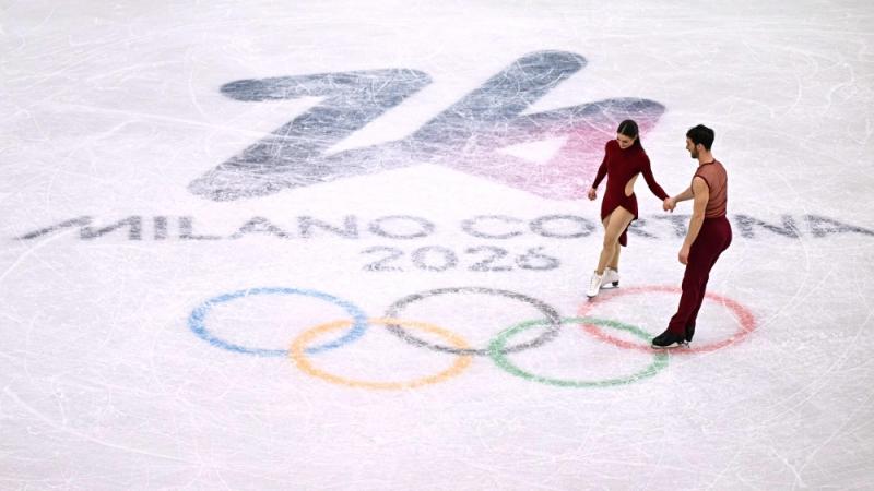 الفرنسيان غيوم سيزيرون ولورانس فورنييه بودري على الحلقات الأولمبية في ختام عرض التزلج الفني في ميلانو (أ.ف.ب)
