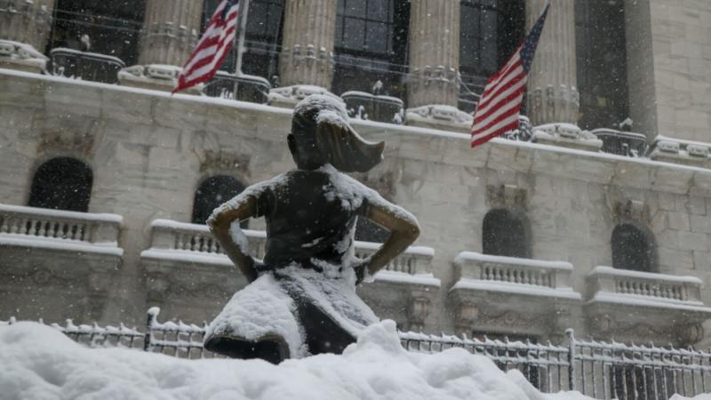 الثلوج تغطي تمثال الفتاة الشجاعة الشهير أمام بورصة نيويورك خلال عاصفة شتوية جديدة في شرق الولايات المتحدة (بلومبيرغ)