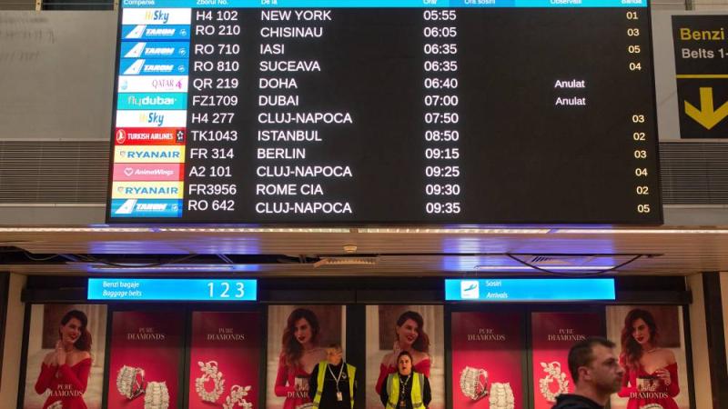 شاشة عرض في صالة الوصول بمطار هنري كواندا الدولي في أوتوبيني رومانيا تعرض رحلات جوية ملغاة قادمة من الشرق الأوسط (أ ب)