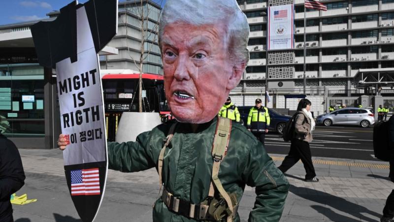 متظاهر يرتدي قناع ترامب خلال مسيرة تنديدا بالحرب  أمام السفارة الأمريكية في سيول (أ.ف.ب)