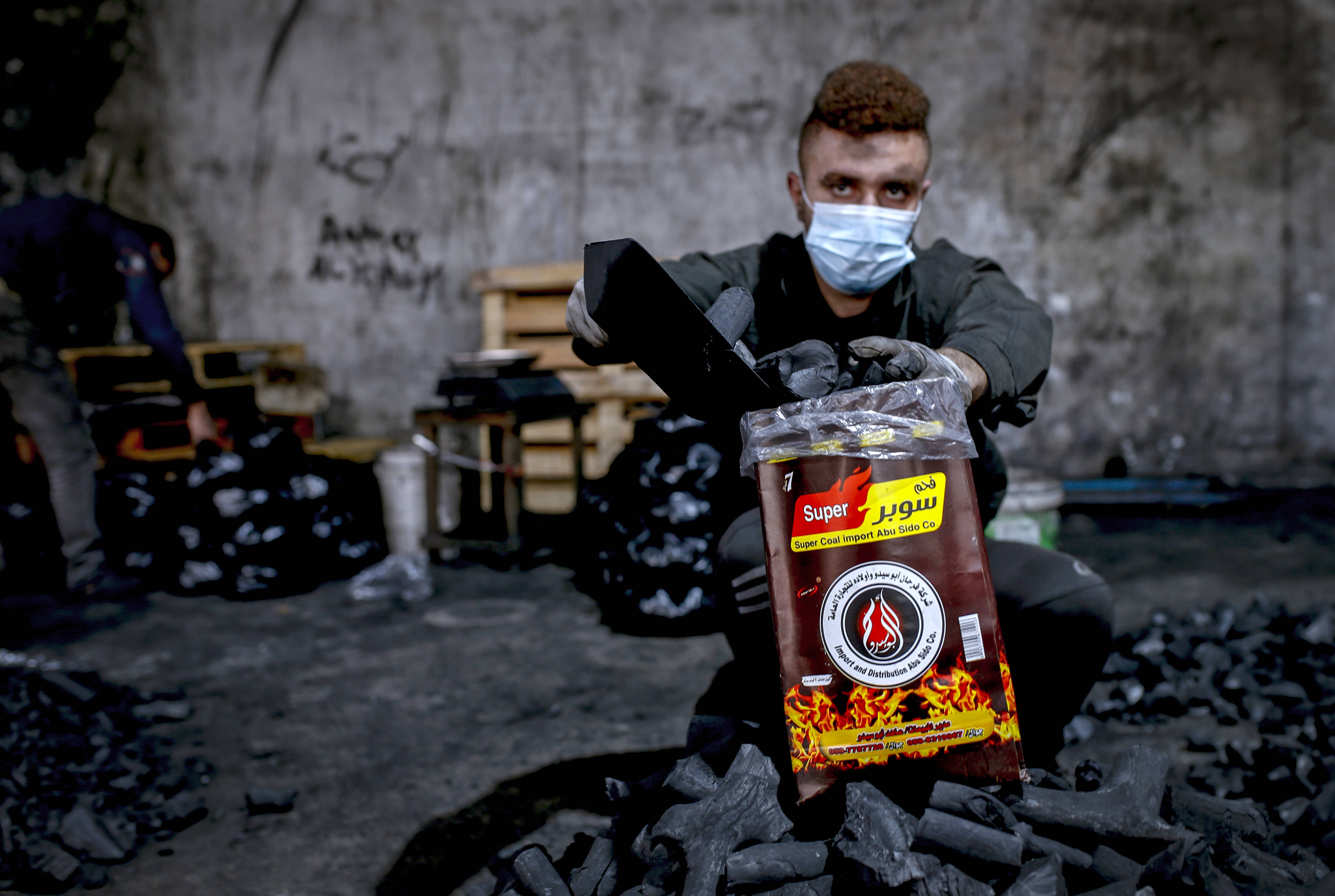 يعمل ثمانية فلسطينيين على مدار العام في منشأة «الحطاب»، أكبر مصنع لإنتاج الفحم في قطاع غز