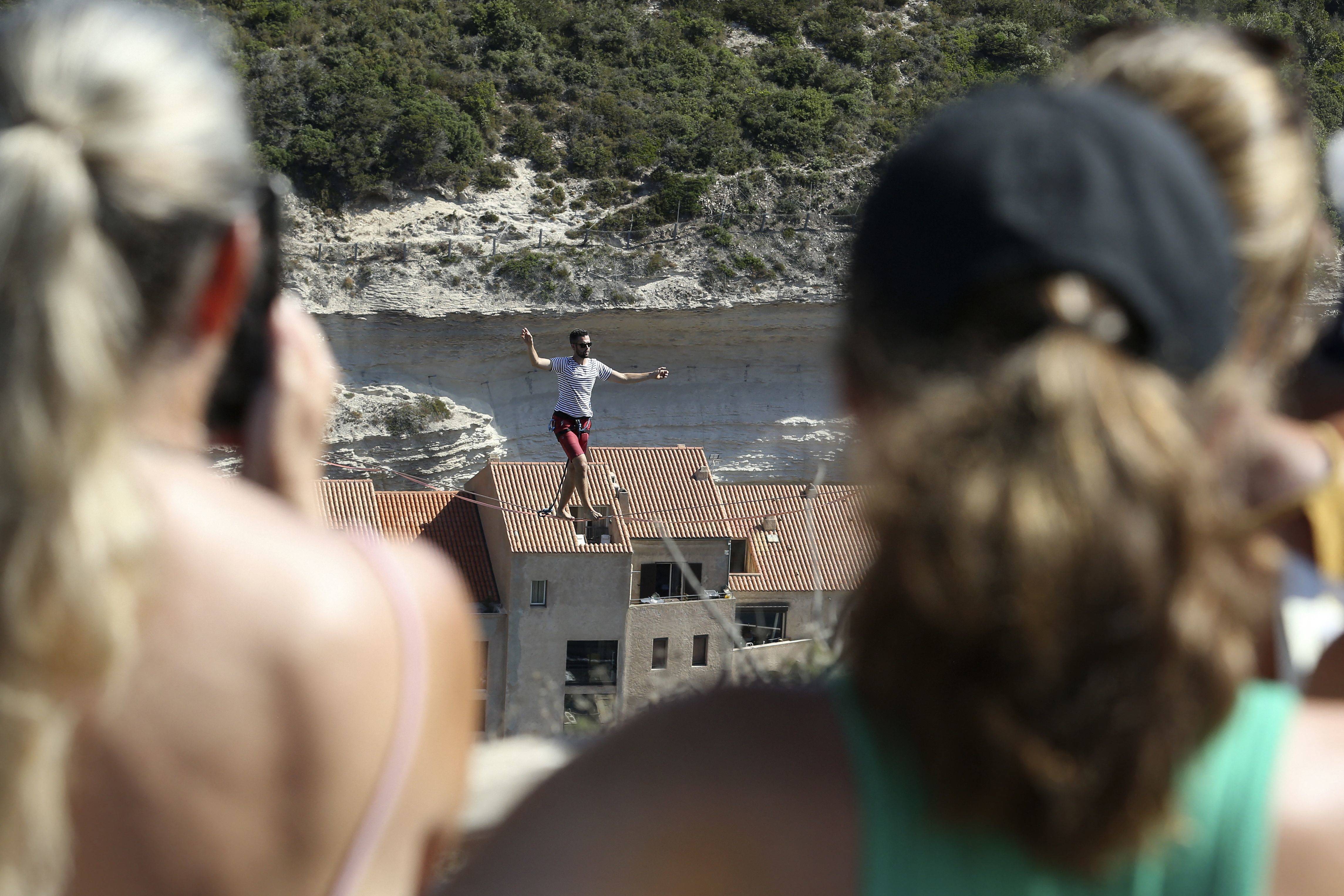 المغامر الفرنسي ناثان بولين يحبس الأنفاس بالمشي على حبل مشدود فوق ميناء بونيفاسيو.