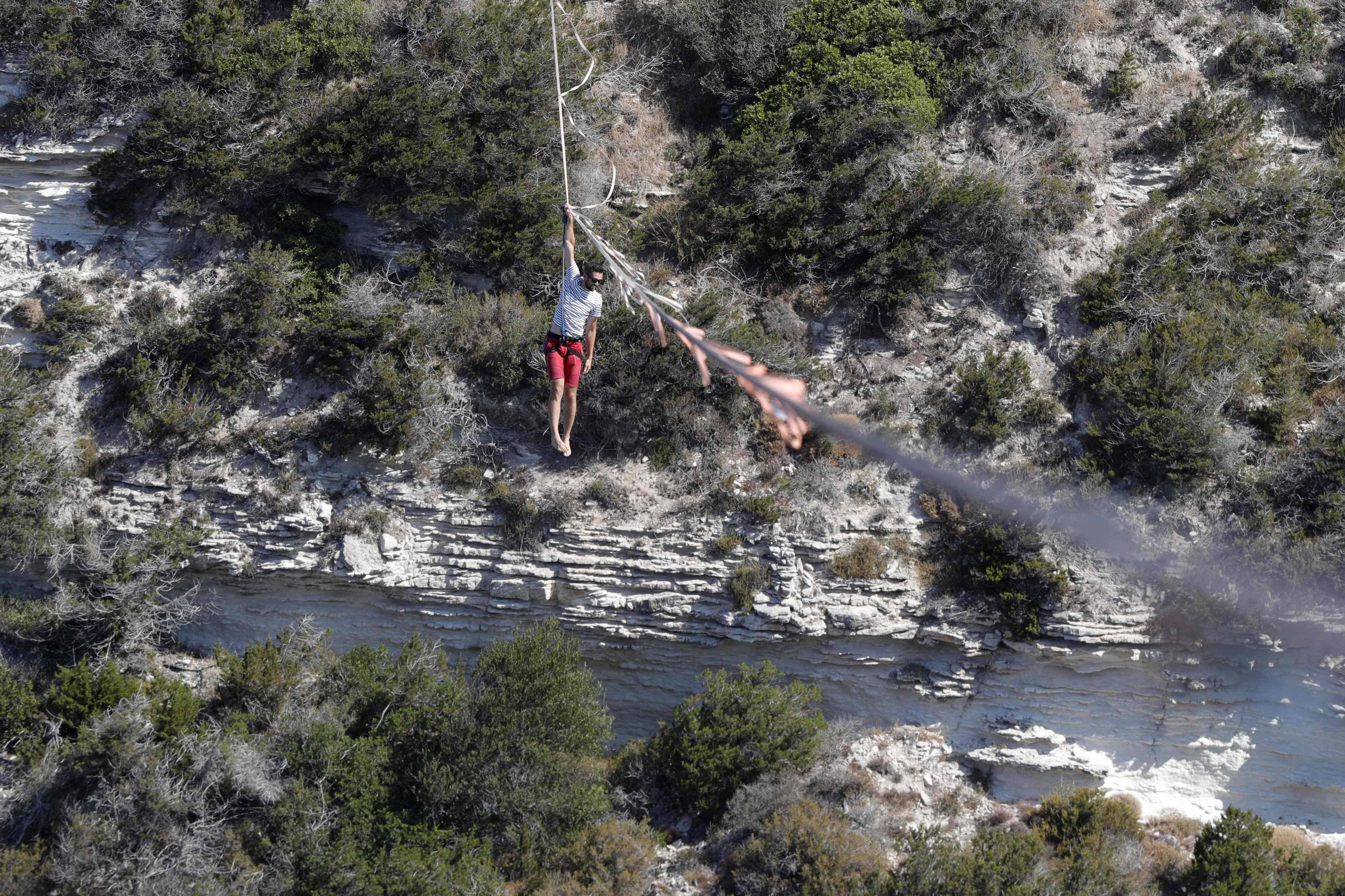 المغامر الفرنسي ناثان بولين يحبس الأنفاس بالمشي على حبل مشدود فوق ميناء بونيفاسيو.