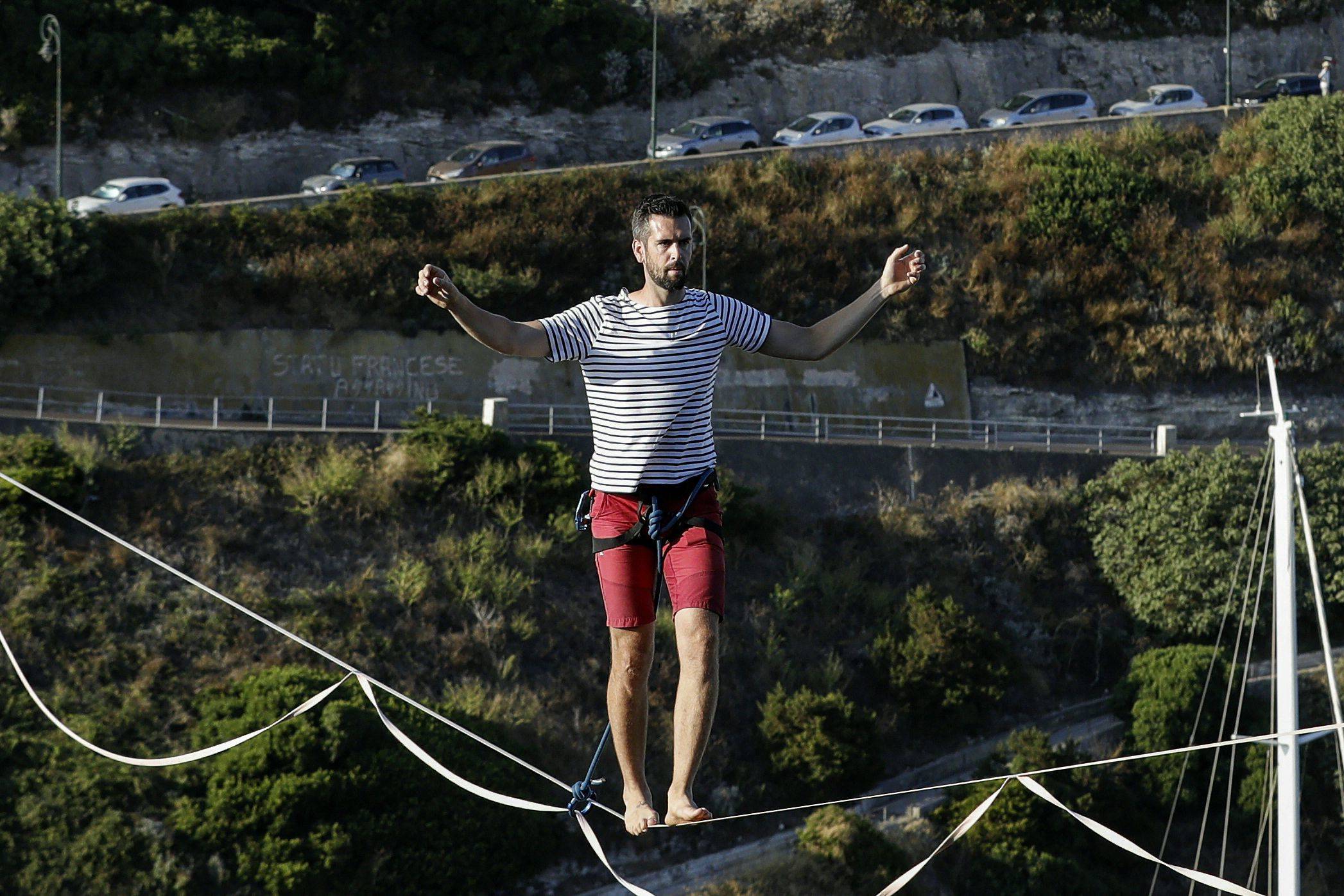 المغامر الفرنسي ناثان بولين يحبس الأنفاس بالمشي على حبل مشدود فوق ميناء بونيفاسيو.