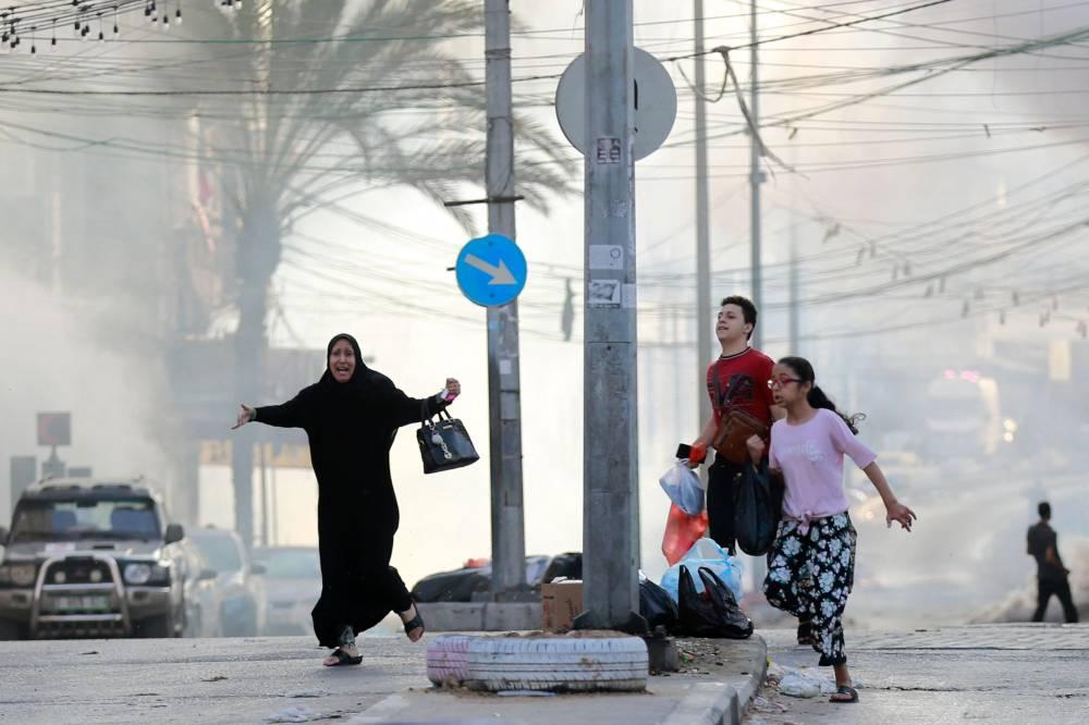مدنيون يركضون للاحتماء من غارة إسرائيلية بالقرب من مستشفى الشفاء في غزة يوم 1 نوفمبر (أ ف ب)