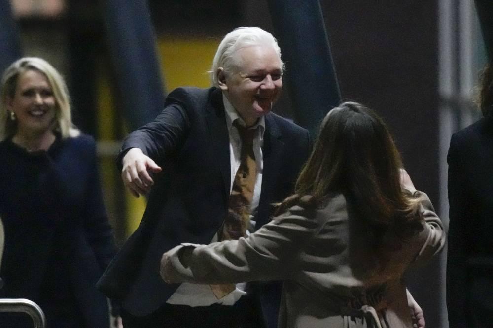 WikiLeaks founder Julian Assange embraces his wife Stella after landing at RAAF air base Fairbairn in Canberra, Australia, Wednesday, June 26 2024. Assange has returned to his homeland Australia aboard a charter jet hours after pleading guilty to obtaining and publishing U.S. military secrets in a deal with Justice Department prosecutors that concludes a drawn-out legal saga.(AP Photo/Rick Rycroft) 1