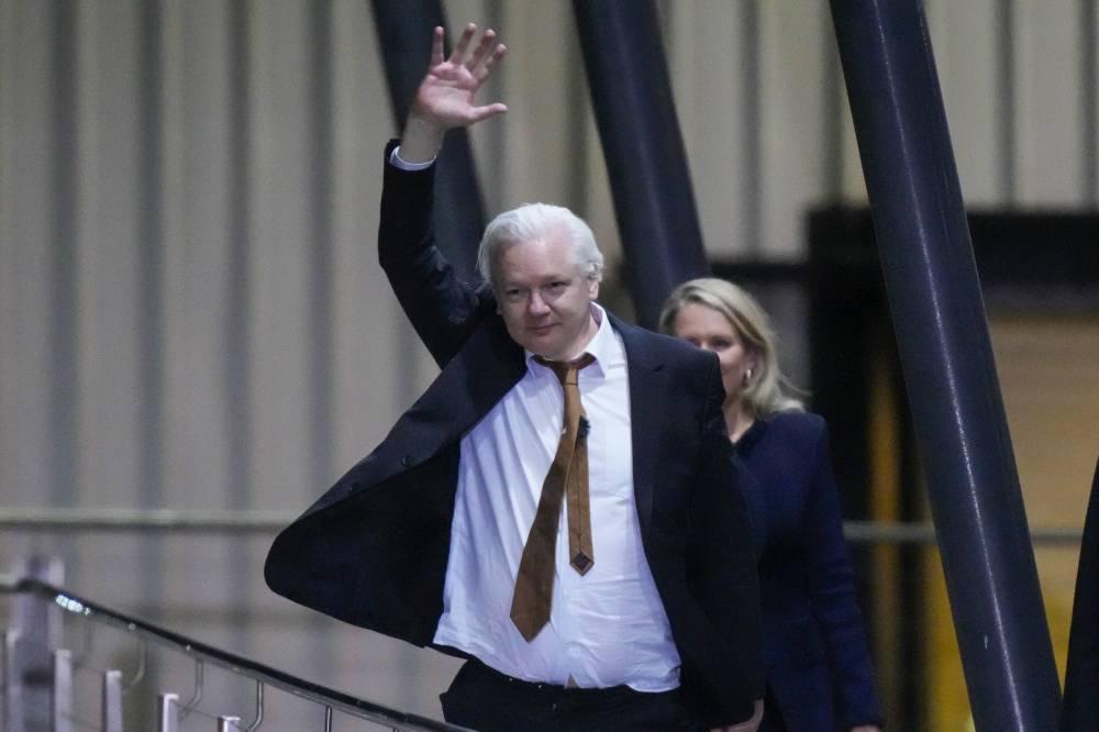 WikiLeaks founder Julian Assange waves after landing at RAAF air base Fairbairn in Canberra, Australia, Wednesday, June 26 2024. Assange has returned to his homeland Australia aboard a charter jet hours after pleading guilty to obtaining and publishing U.S. military secrets in a deal with Justice Department prosecutors that concludes a drawn-out legal saga.(AP Photo/Rick Rycroft) 1