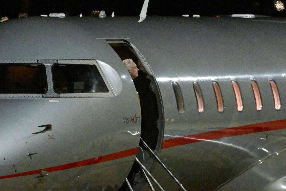 WikiLeaks founder Julian Assange emerges from the plane after arriving at Canberra Airport in Canberra on June 26, 2024, after he pleaded guilty at a US court in Saipan to a single count of conspiracy to obtain and disseminate US national defence information. WikiLeaks founder Julian Assange returned home to Australia to start life as a free man June 26 after admitting he revealed US defence secrets in a deal that unlocked the door to his London prison cell. (Photo by WILLIAM WEST / AFP) 1