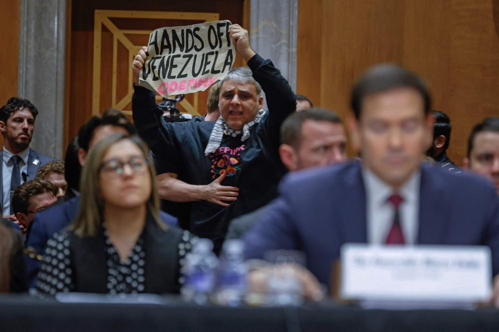 ناشط يقاطع رومبيو ويرفع لافتة تدعو لوقف التدخل بشؤون فنزويلا