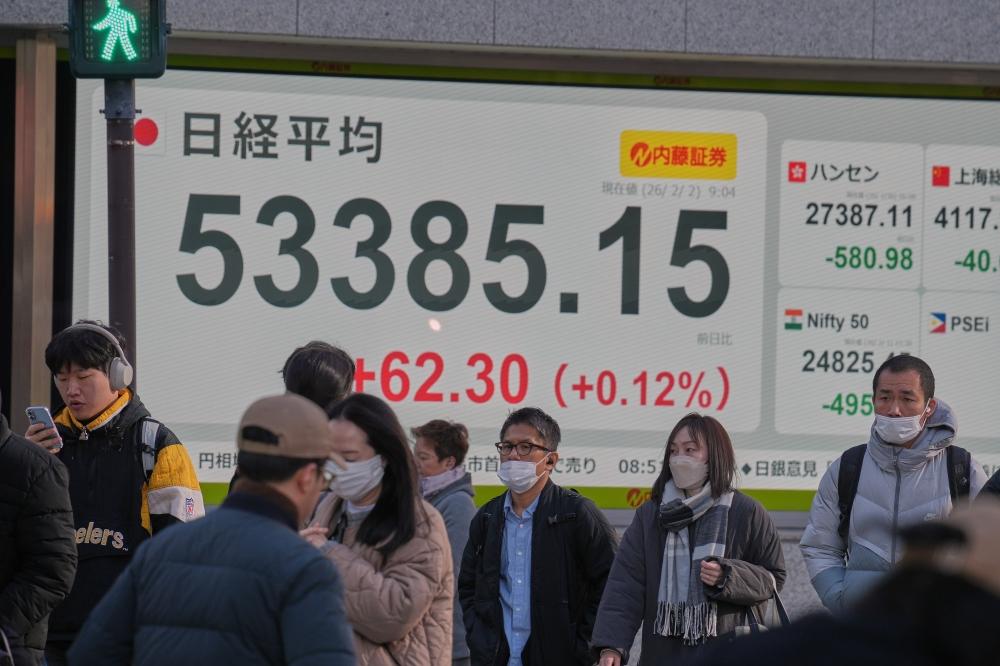 مارة أمام شاشة للأسهم اليابانية في طوكيو