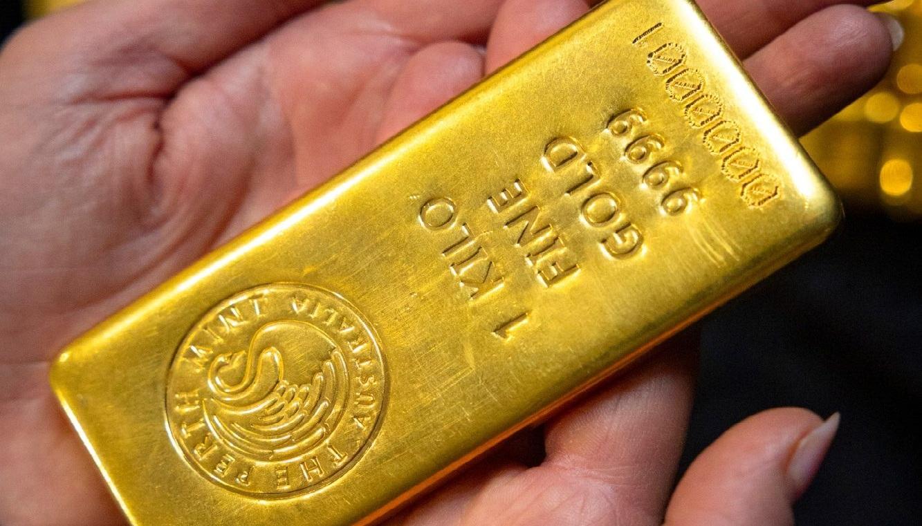 موظفة تعرض سبيكة ذهبية في أستراليا