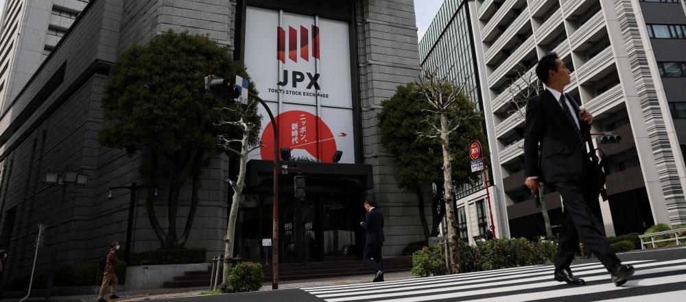 رجل يمر أمام مبنى بورصة طوكيو