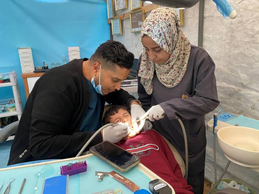 A dentist in Gaza treats patients in a tent after Israel destroys his clinic