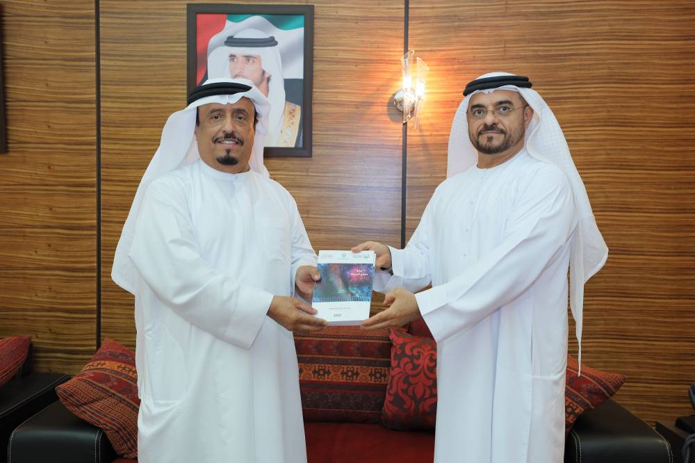 ضاحي خلفان يتسلم الكتاب من جاسم العوضي