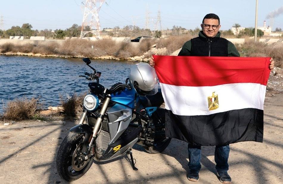 المغامر علي عبده يرفع علم مصر بجوار دراجته الكهربائية