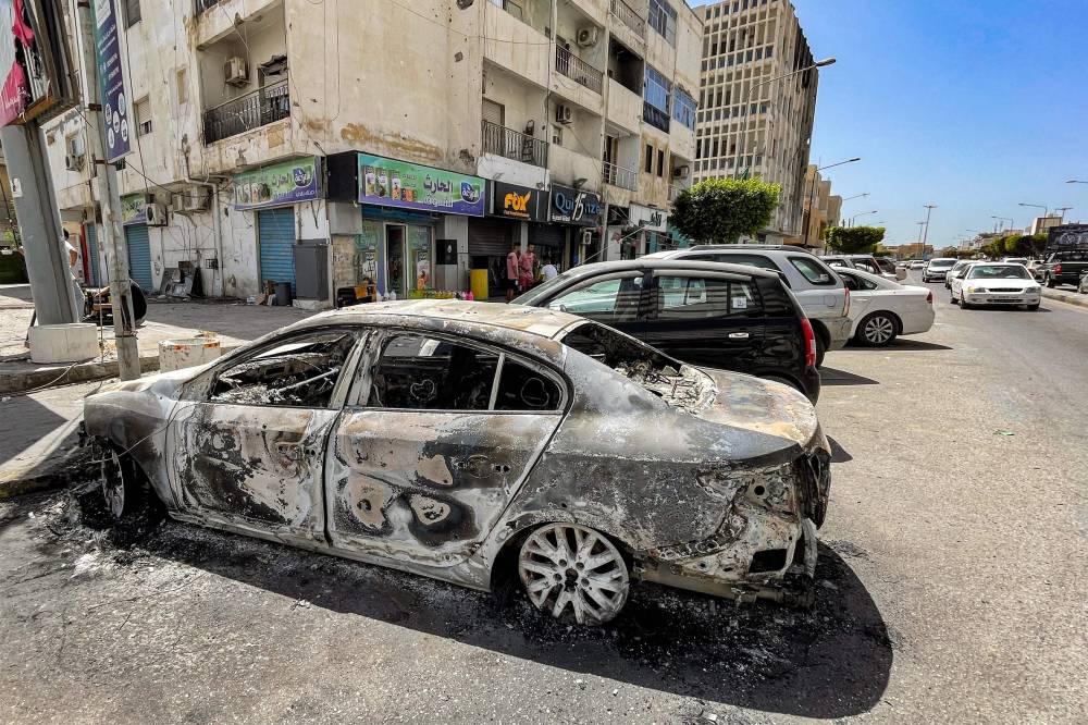 بقايا مركبة دمرت في أعقاب اشتباكات في منطقة الزاوية وسط العاصمة الليبية طرابلس(أ ف ب )