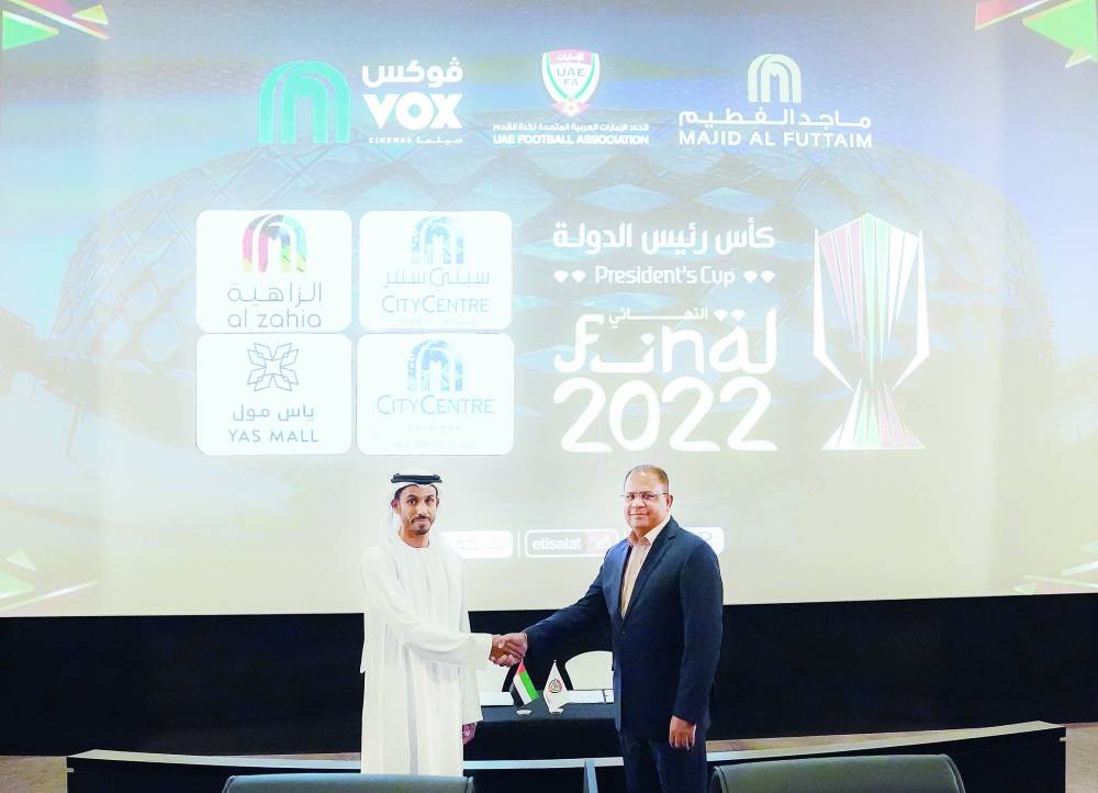 الظاهري يصافح باتني بعد توقيع الاتفاقية