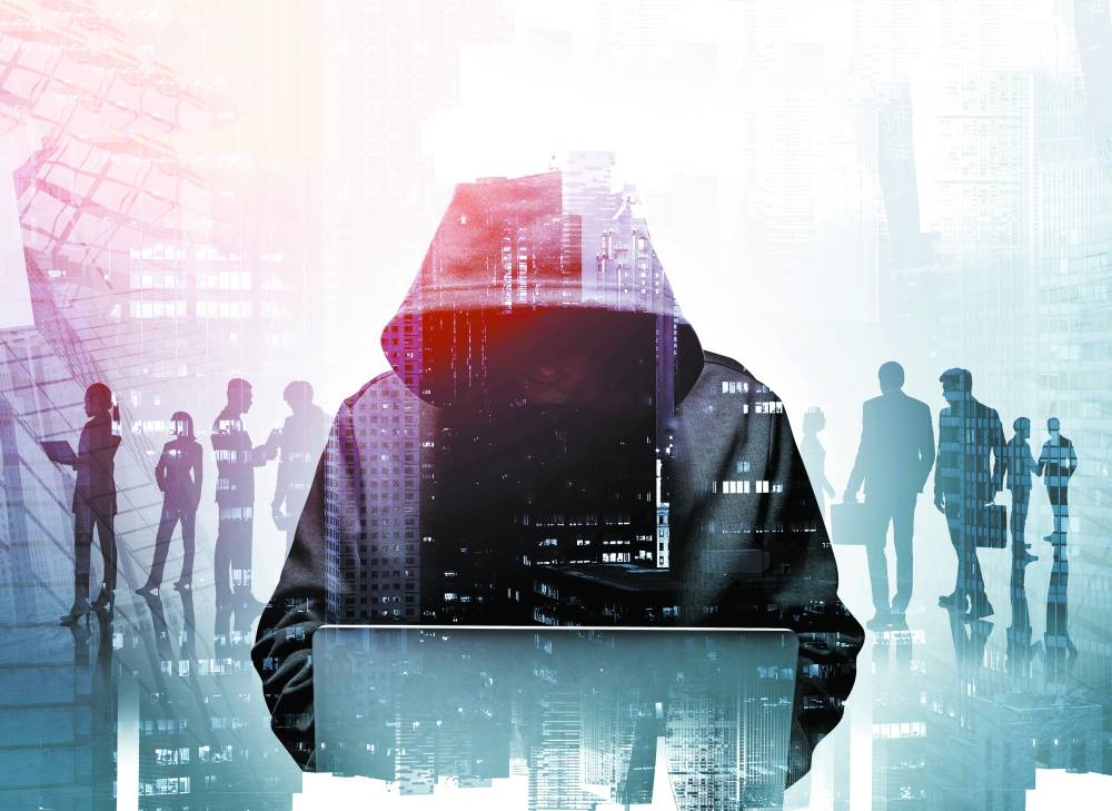Unrecognizable young hacker in hoodie using laptop in blurry city. Business people. Concept of cybersecurity. Toned image double expsoure