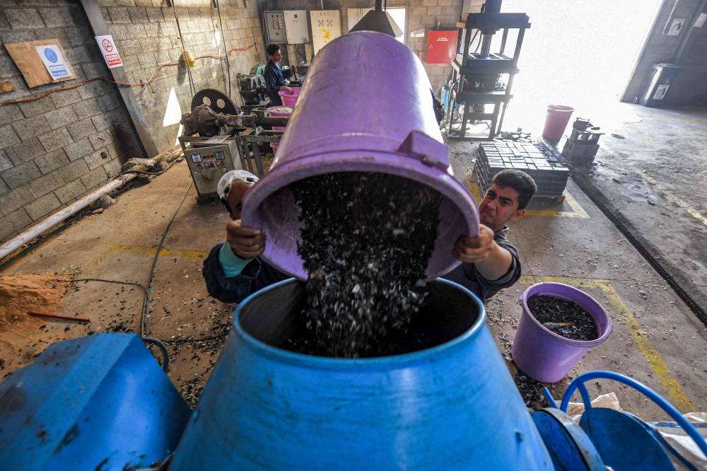 عاملان في مصنع تدوير (أ.ف.ب)