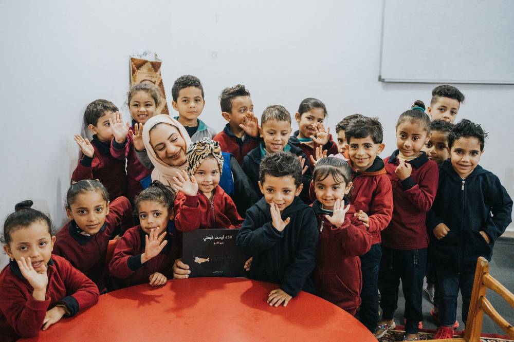مروة العقروبي مع بعض الأطفال المستفيدين من الكتب