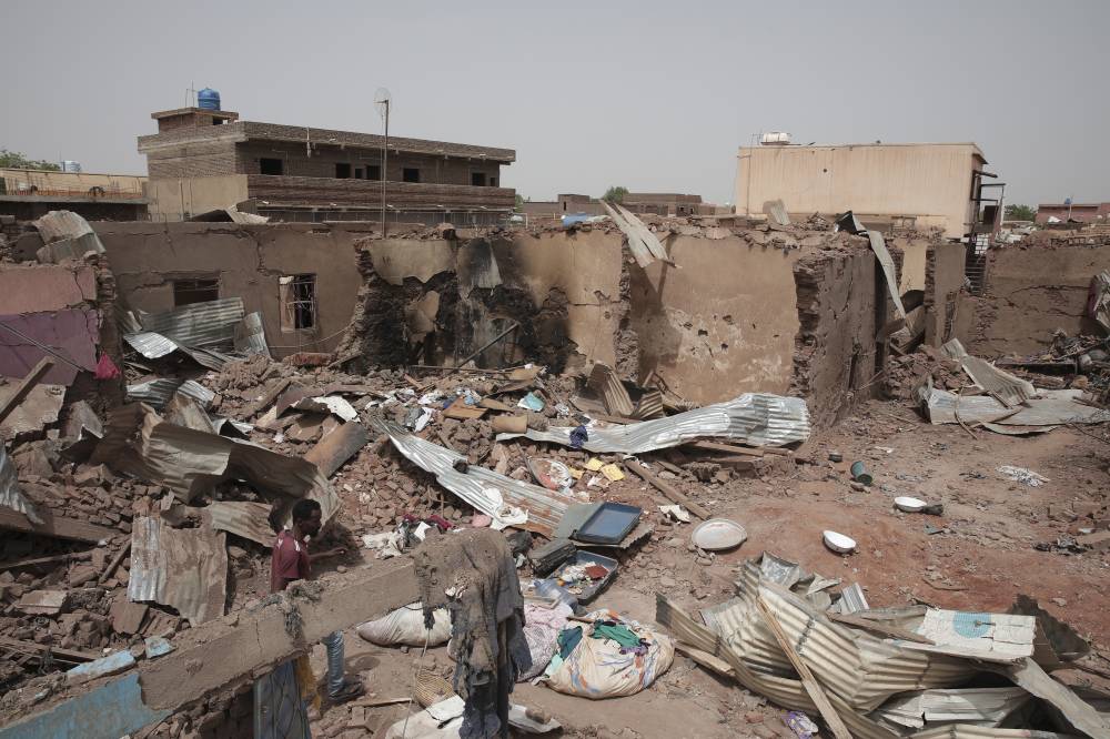 سوداني يعبر من أمام منازل دمرت في اشتباكات الخرطوم (أ ب ) 
