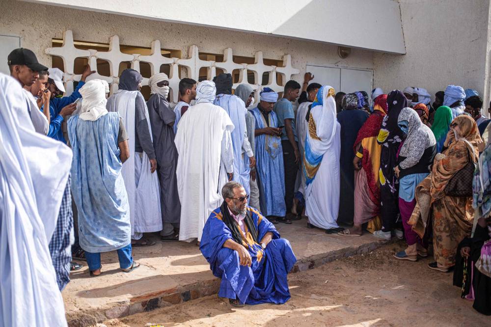 ناخبون من الجنسين في انتظار فتح أبواب مركز اقتراع في نواكشوط (أ.ف.ب)