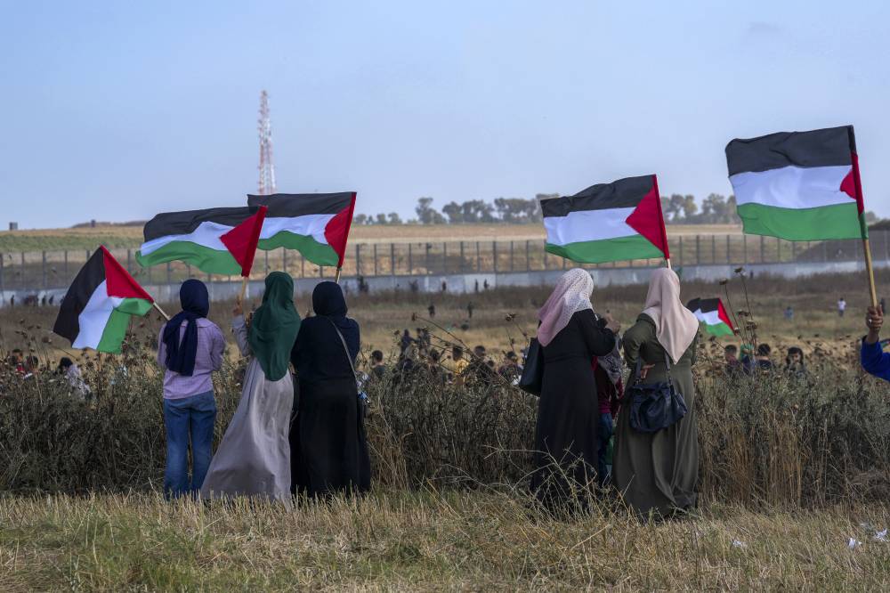 فلسطينيون خلال احتجاج على طول الحدود مع إسرائيل شرق مدينة غزة (أ ب)