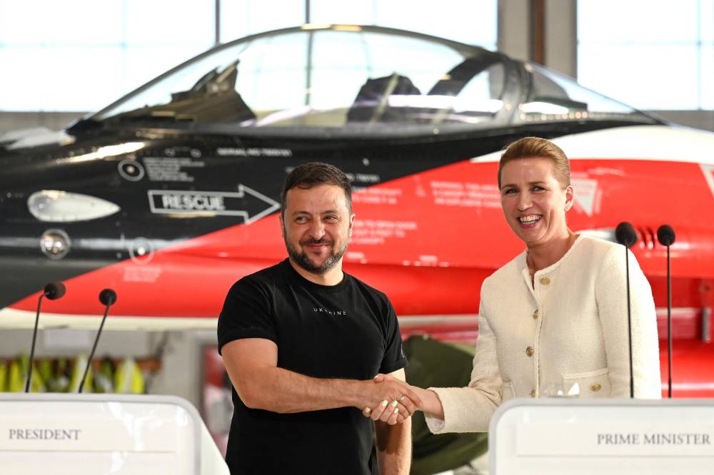 زيلينسكي ورئيس الوزراء الدنماركي ميت فريدريكسن في مؤتمر صحفي أمام طائرة «إف-16» في قاعدة جوية شمال الدنمارك (اف ب )