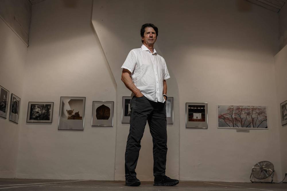 جيمس بالوغ أمام يقف خلال جلسة تصوير على موقع معرضه خلال مهرجان «فيزا بور ليماج» في بربينيان، جنوب غرب فرنس(أ.ف.ب)