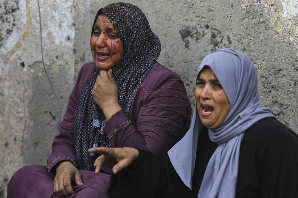 سيدتان فلسطينيتان تبكيان أثناء في أعقاب غارات إسرائيلية استهدفت مدينة غزة (أ ب)