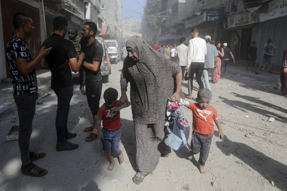 فلسطينيون يقومون بإجلاء الجرحى في أعقاب غارة إسرائيلية على مخيم البريج للاجئين(أ ب)