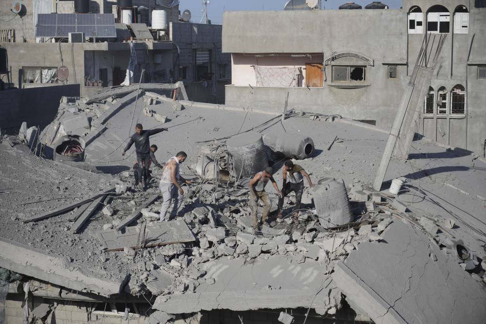  (أ ب) فلسطينيون يبحثون عن ناجين بعد غارة إسرائيلية على مخيم النصيرات