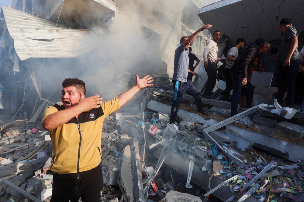 فلسطيني يستغيث في موقع الغارات الإسرائيلية على خان يونس
(رويترز)