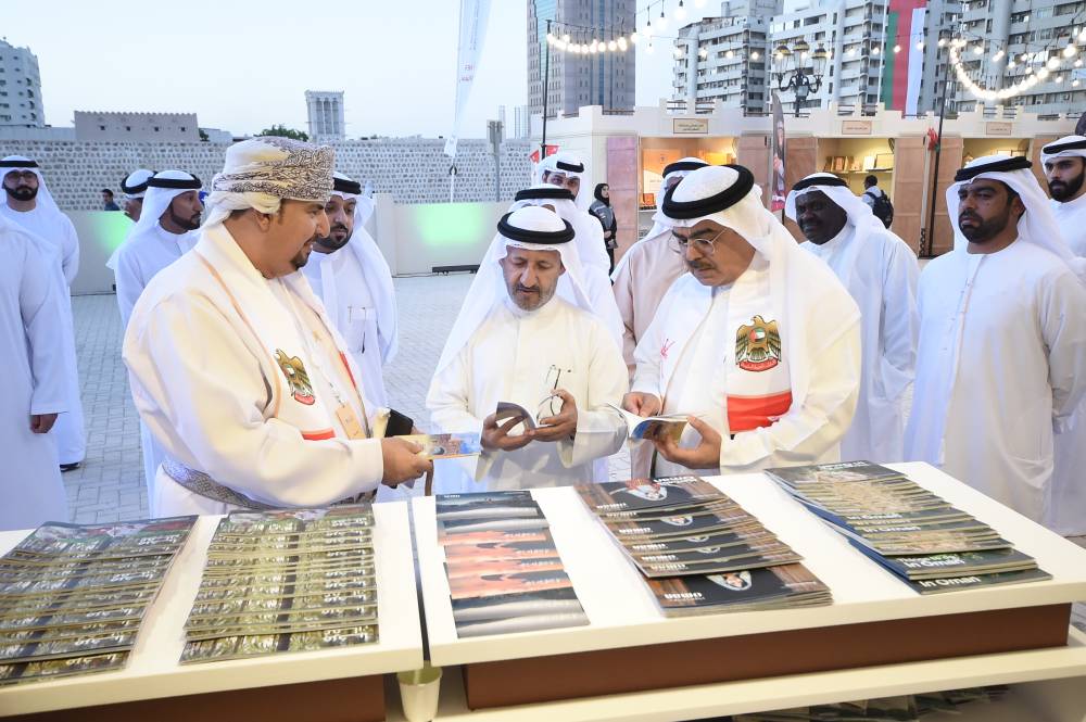 الحضور يطالعون كتيبات بالفعالية