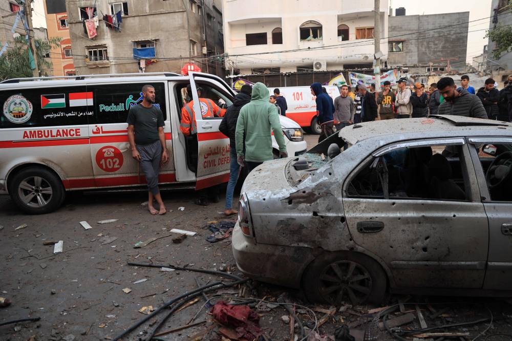 Palestinians gather near an ambulances following Israeli bombardment in Rafah, in the southern Gaza Strip on December 12, 2023, amid ongoing battles between Israel and the Palestinian militant group Hamas. (Photo by SAID KHATIB / AFP)
