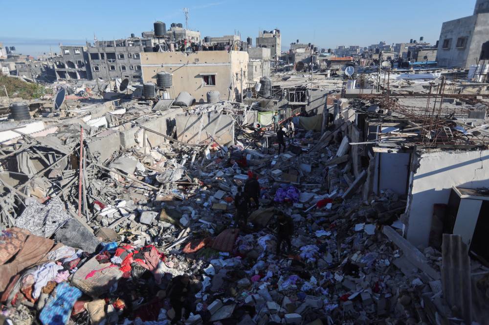  (رويترز) فلسطينيون يتفقدون موقع غارة إسرائيلية على رفح