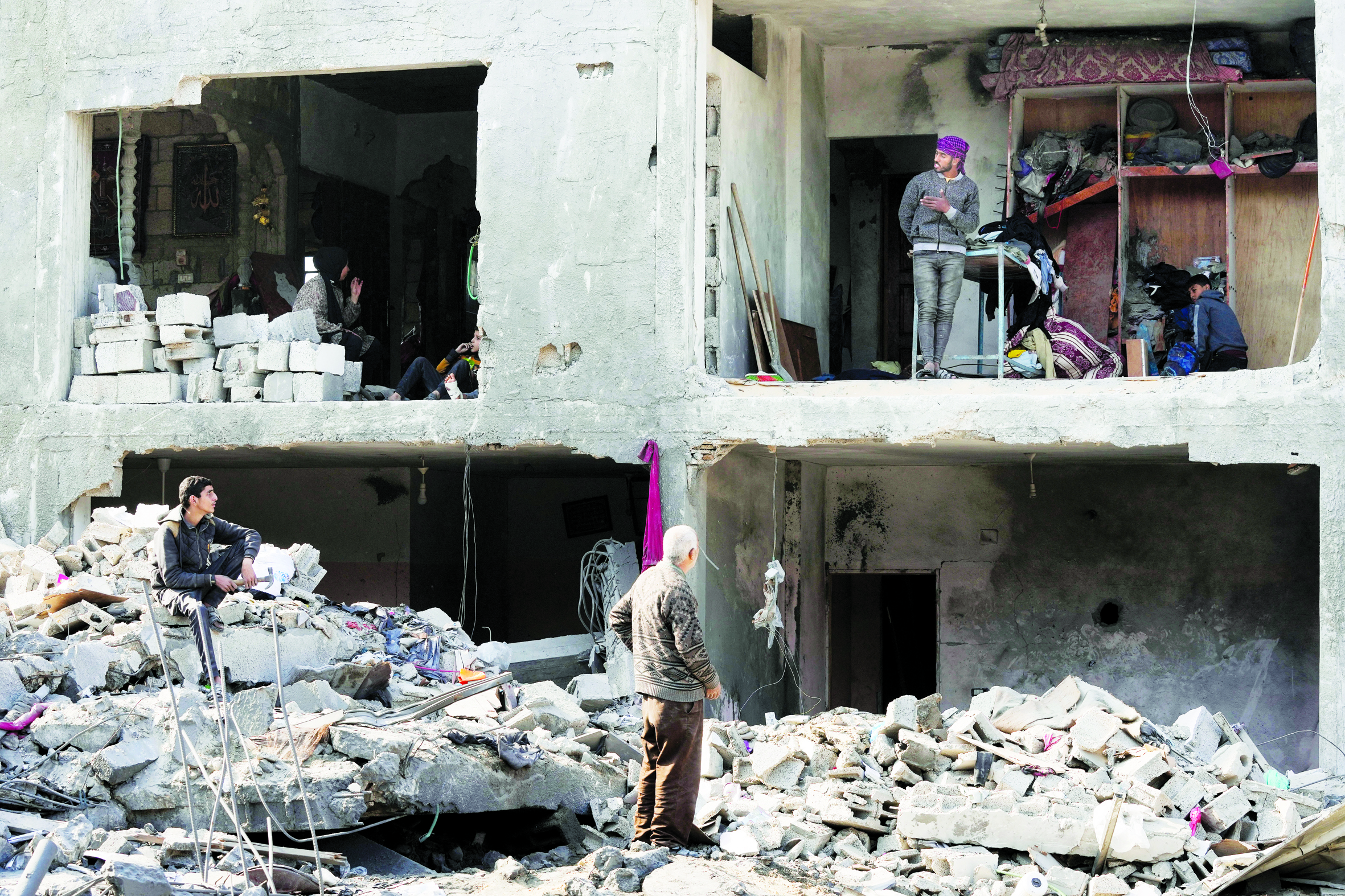  فلسطينيون داخل مبنى مدمر إثر القصف الإسرائيلي على غزة (أ ب)